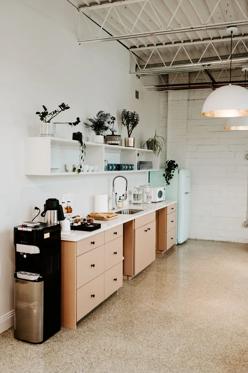 The studio's light wood tea and coffee counter with plants