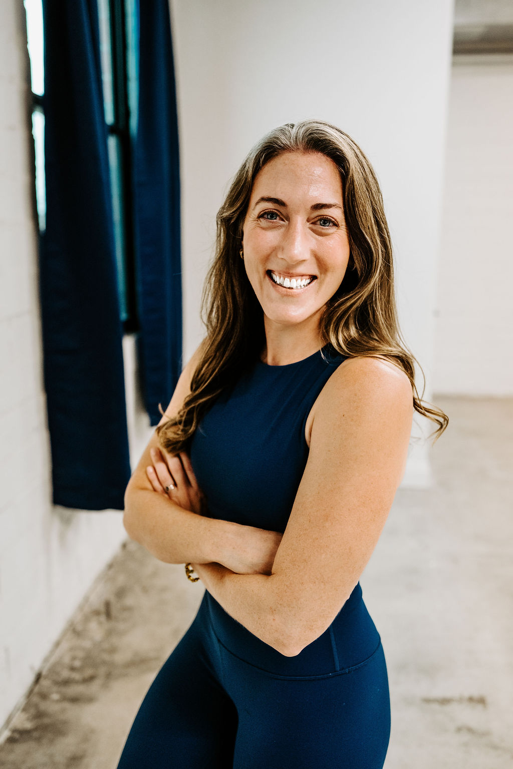 Paula smiling with arms crossed in the studio