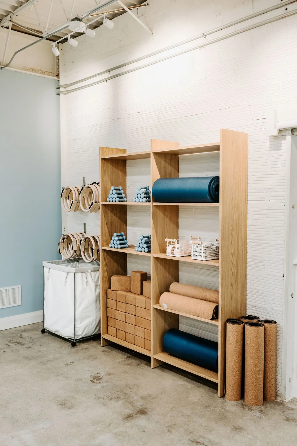 Wooden shelves stocked with mats, blocks, rings and light weights